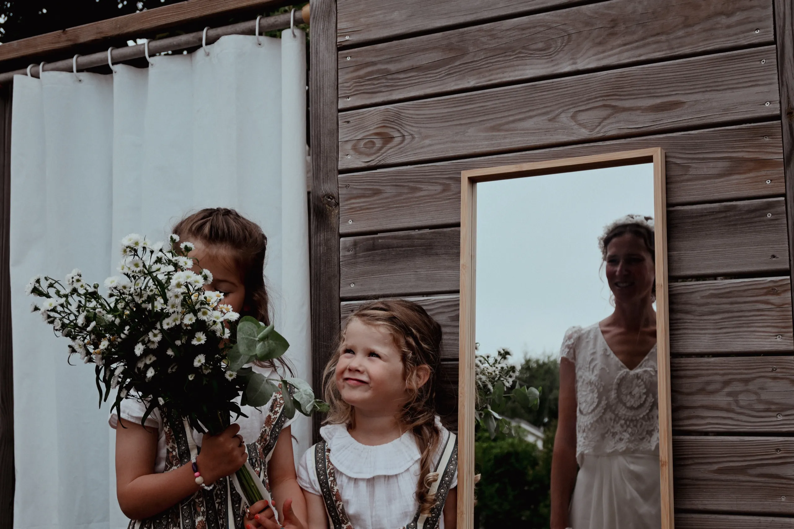 Deux enfants d’honneur tiennent le bouquet devant un miroir