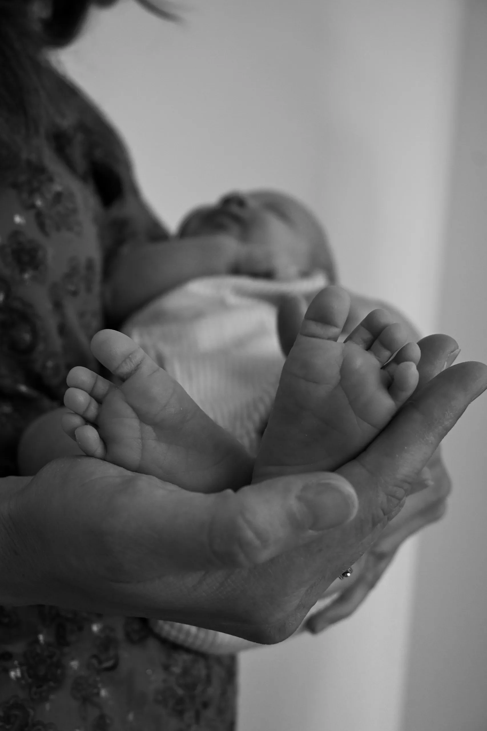 Un nouveau-né endormi au creux des mains de ses parents
