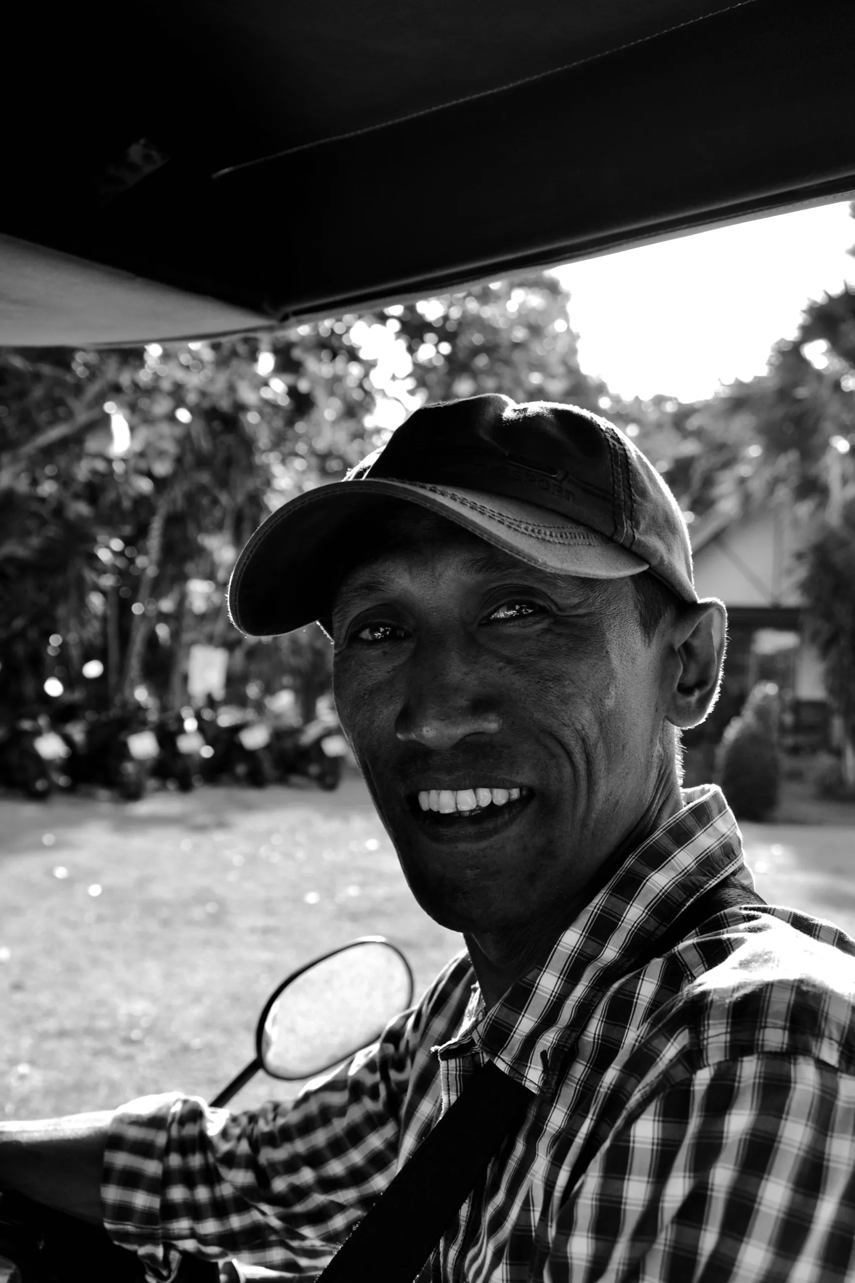 Portrait souriant d’un homme à lunettes, en noir et blanc