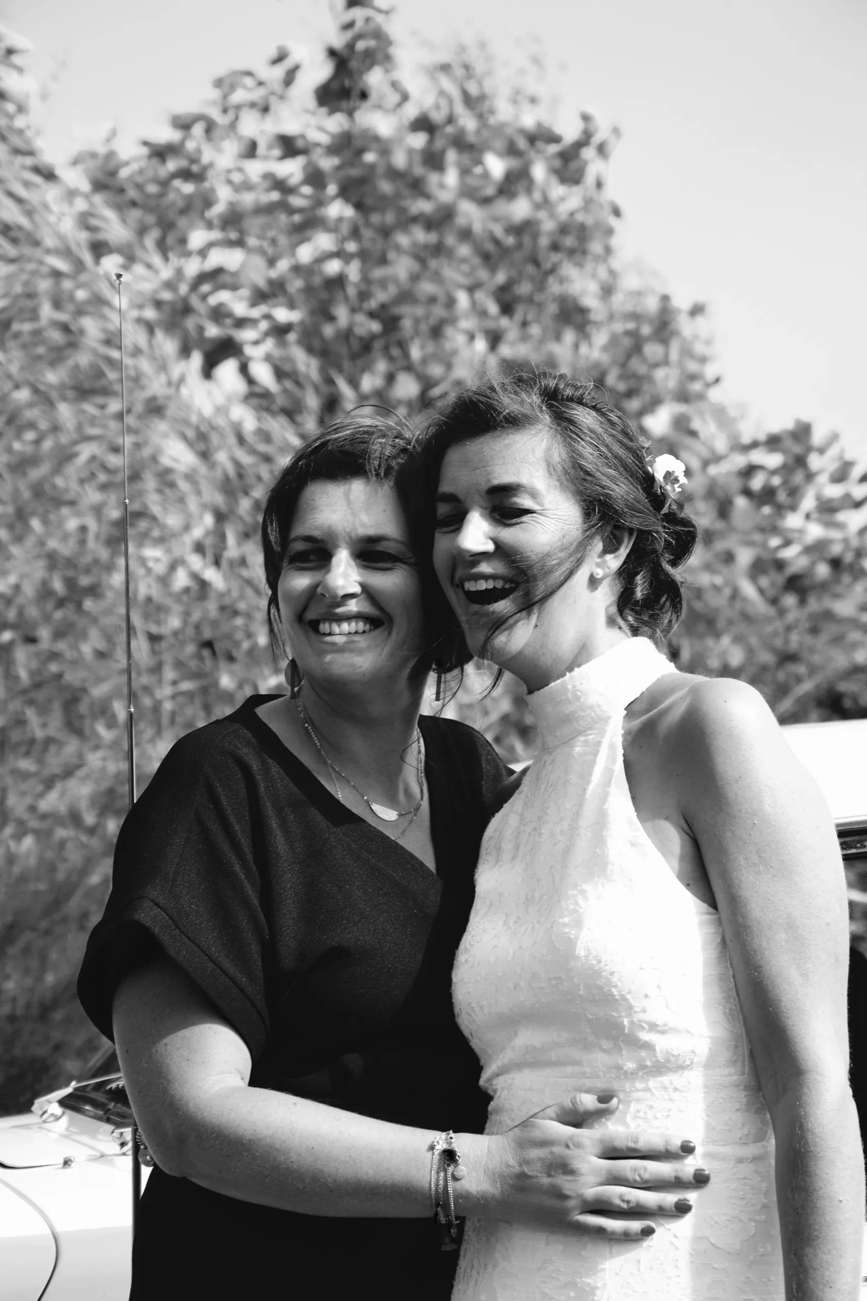 Deux femmes enlacées rient ensemble en extérieur