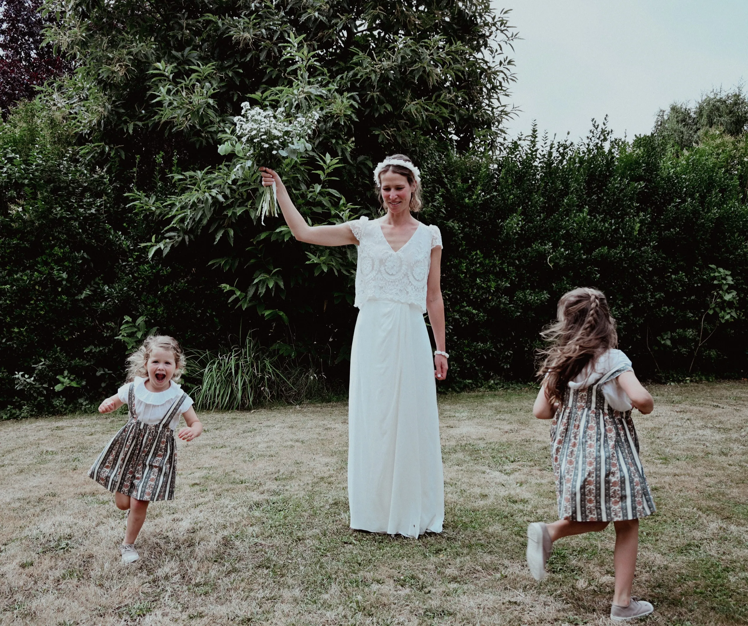La mariée joue avec les enfants d’honneur dans le jardin