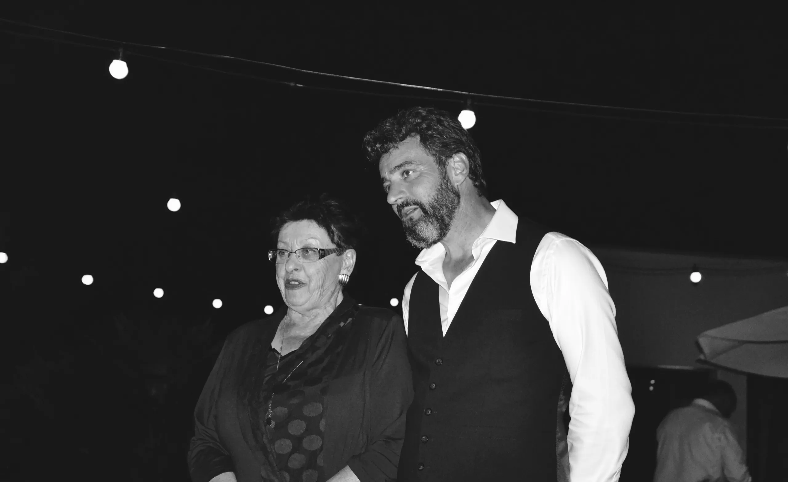 Un couple d’invités sous les guirlandes, en fin de soirée
