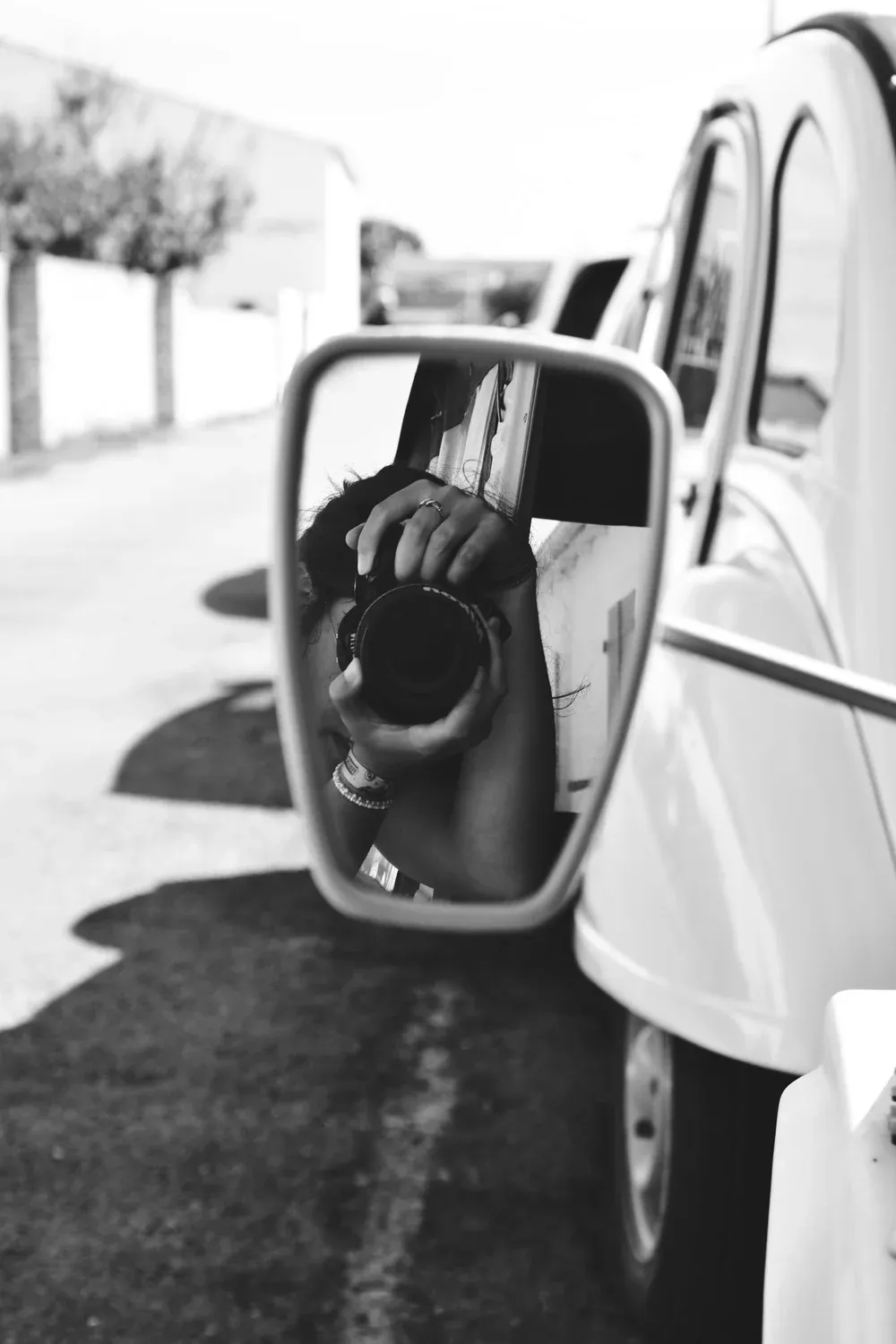 Lou-Anne en train de photographier, reflétée dans le rétroviseur d’une 2CV